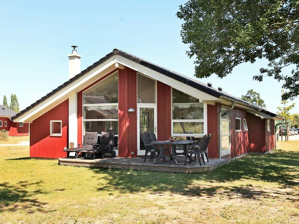 ein rotweißes Haus mit einem Tisch und Stühlen in der Unterkunft 8 person holiday home in Gro enbrode in Großenbrode