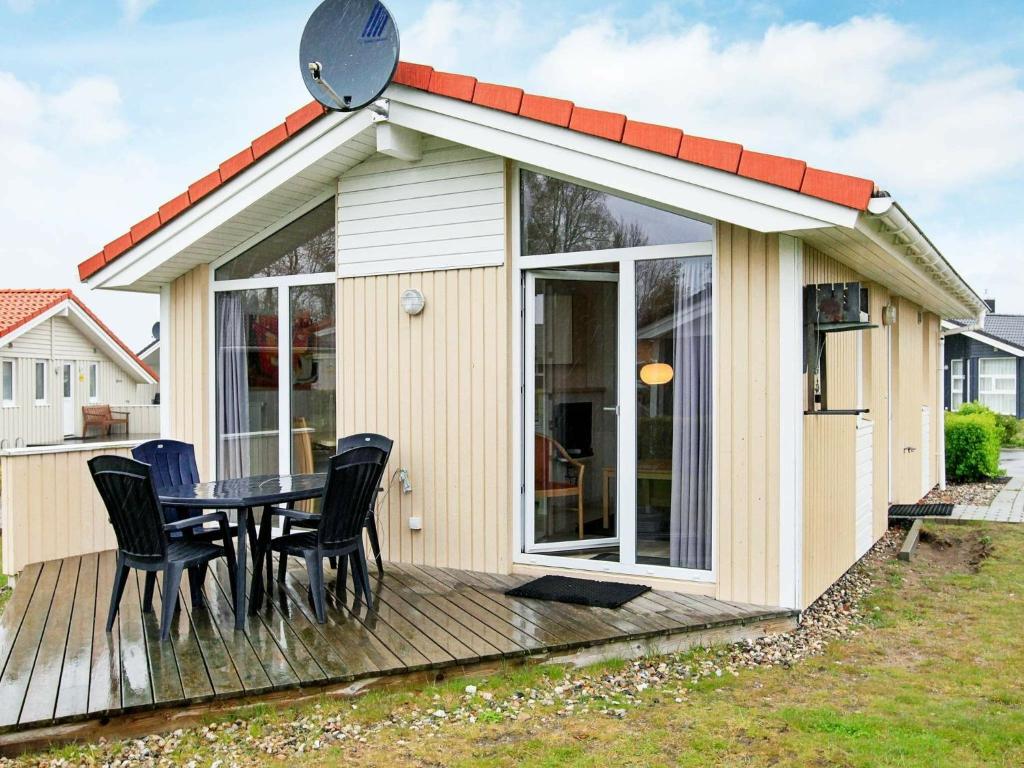 a small house with a table and chairs on a deck at Two-Bedroom Holiday home in Grömitz 10 in Grömitz
