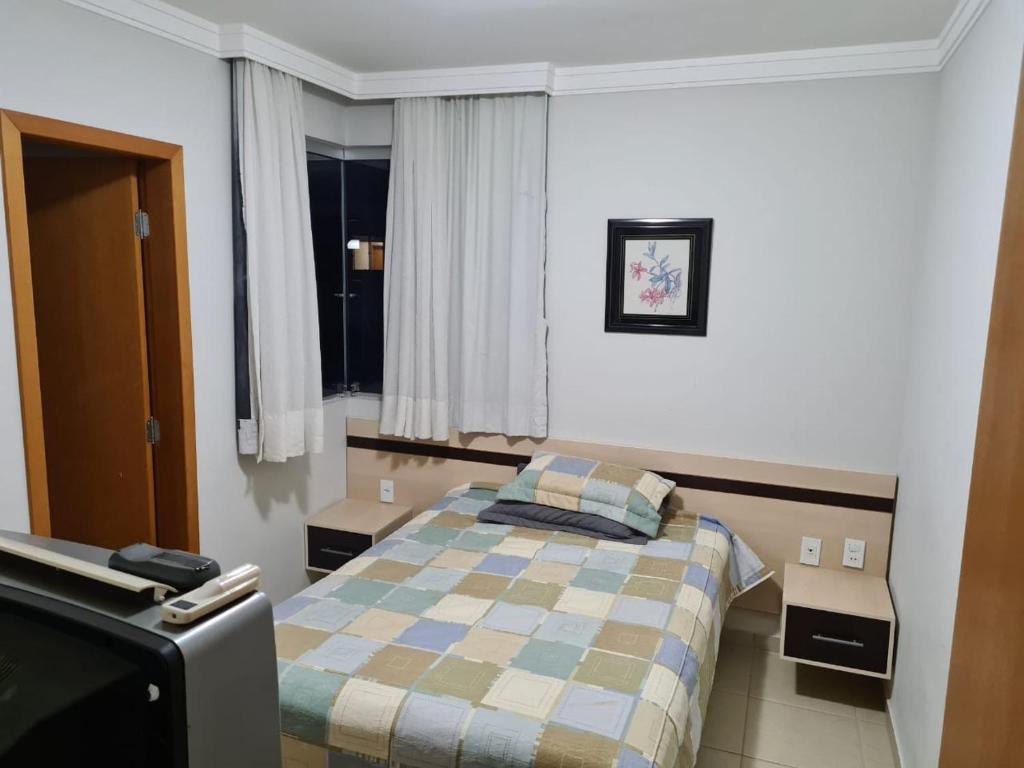 a bedroom with a bed and a tv in it at Rio Quente Aguas da Serra Apart in Rio Quente