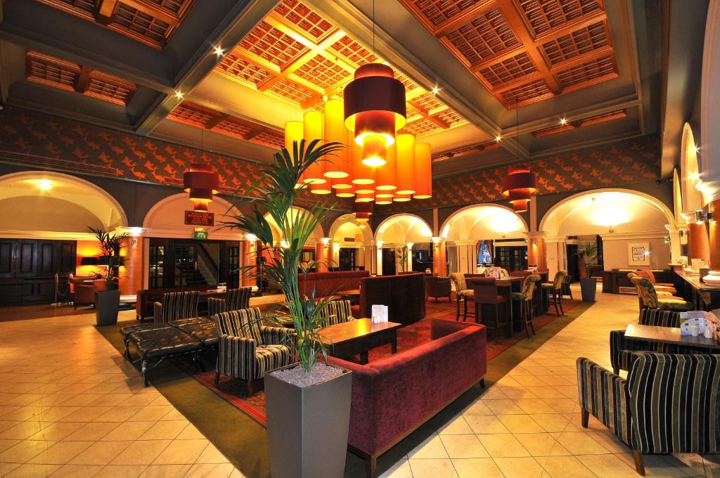 eine Lobby mit einem Restaurant mit Tischen und Stühlen in der Unterkunft The Royal Hotel Hull in Hull