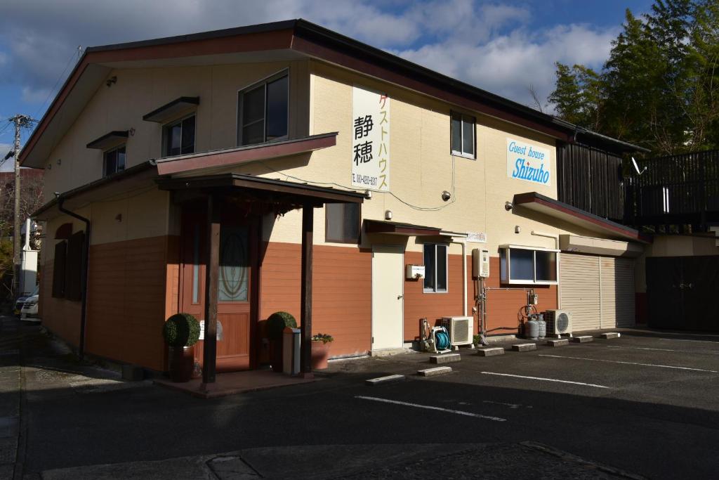 ein Gebäude in einer Straße neben einem Parkplatz in der Unterkunft Guest House Shizuho in Takachiho