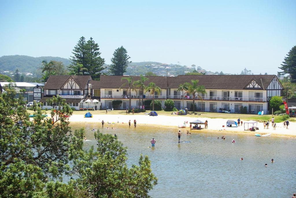 un groupe de personnes sur une plage dans l'eau dans l'établissement The Clan Terrigal, à Terrigal