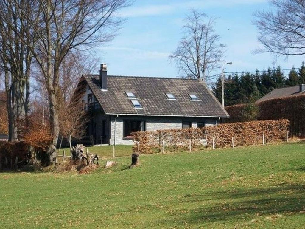 a house with a stone wall in a field at Stylish Holiday Home in Xhoffraix with Terrace in Xhoffraix
