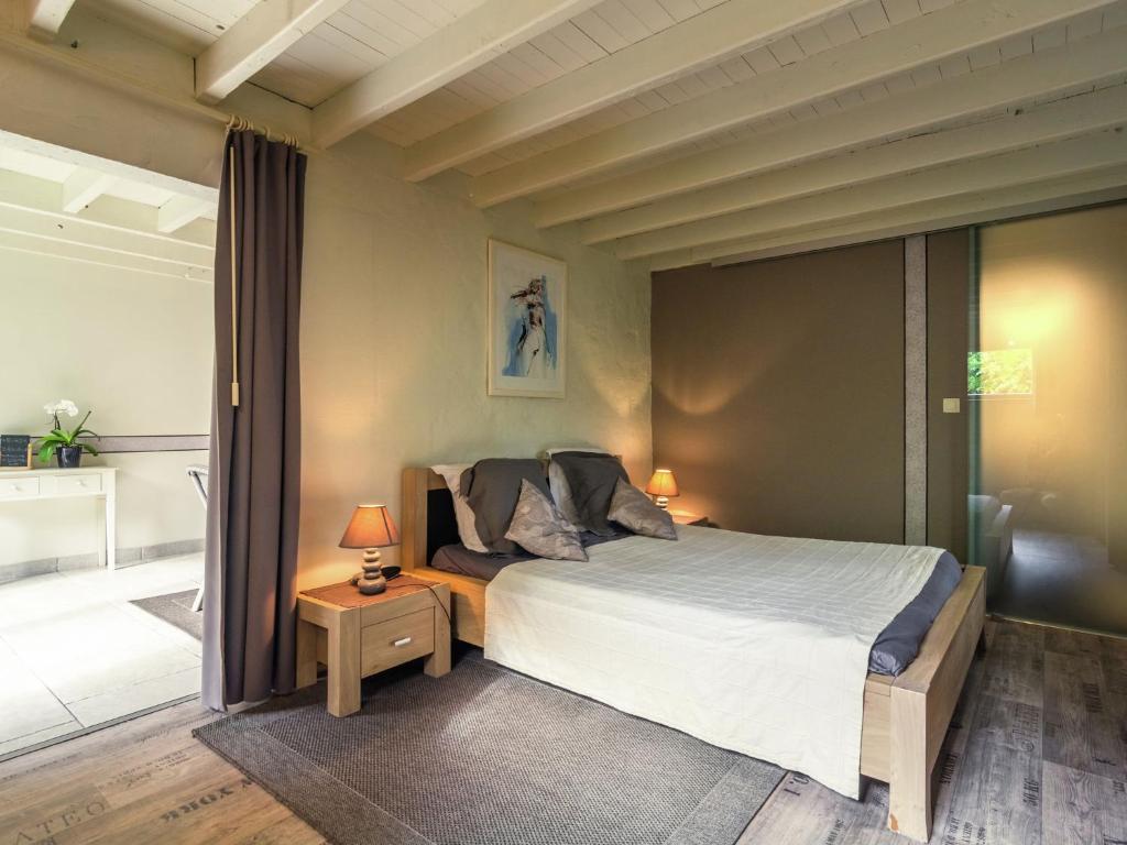 a bedroom with a large bed and a bathroom at This accommodation is full of atmosphere and on a beautiful estate in Zedelgem