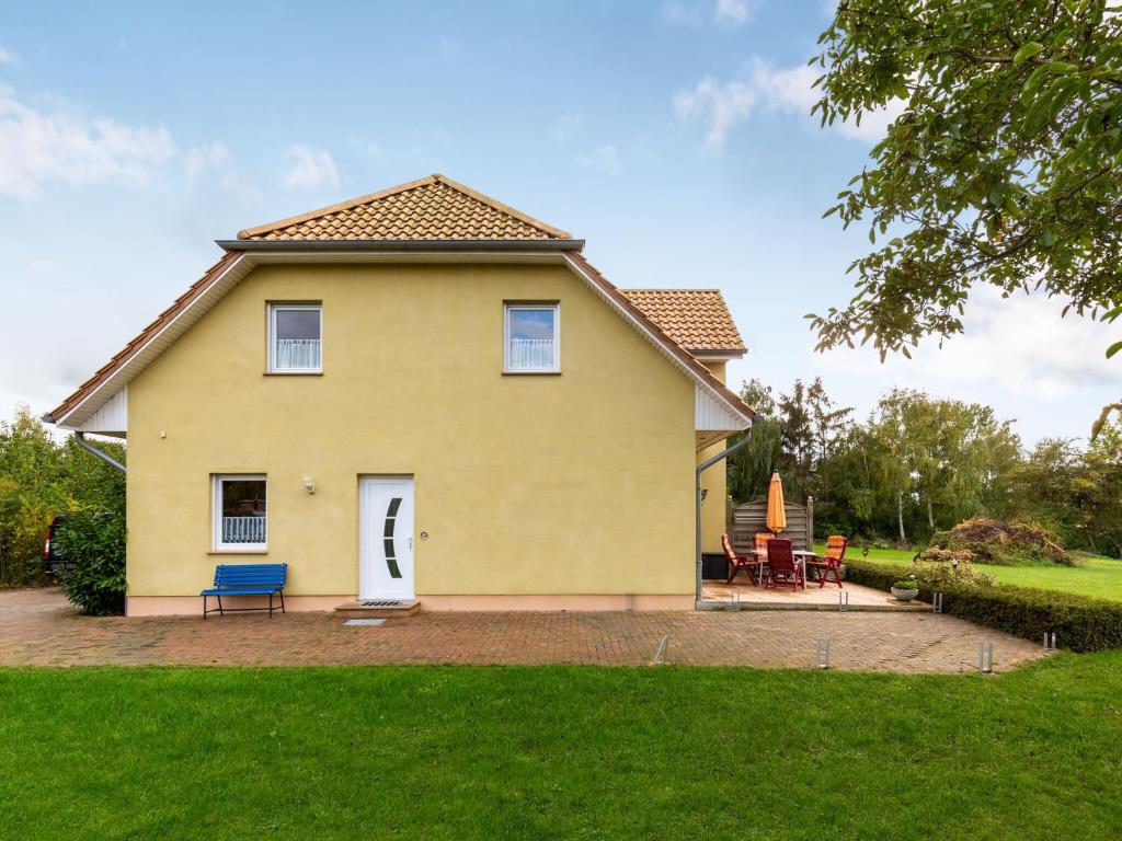 ein gelbes Haus mit einer blauen Bank im Hof in der Unterkunft Modern Apartment in Wismar near Baltic Sea in Wismar