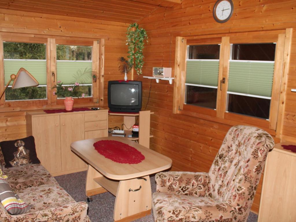 a living room with a tv and a table and chairs at Pretty Bungalow in Neubukow with Garden, Roof Terrace, BBQ in Neubukow