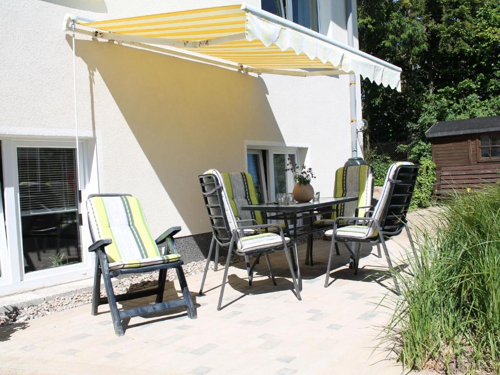 un patio con mesa y sillas bajo una sombrilla en Apartment in Ravensberg with BBQ, Terrace, Fenced Garden en Ravensberg