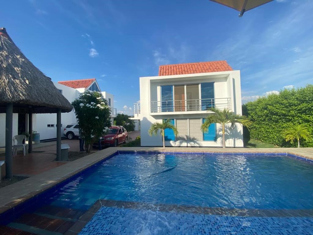 una villa con piscina di fronte a una casa di Casa Campestre, exclusiva para ti y tu Familia a Ricaurte