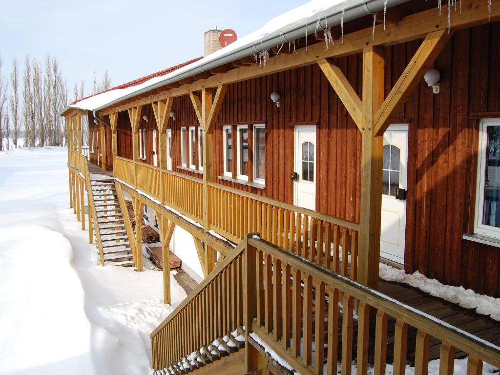 eine Holzhütte im Schnee mit einer schneebedeckten Veranda in der Unterkunft Appealing holiday home in Ciggiano with private pool in Boddin
