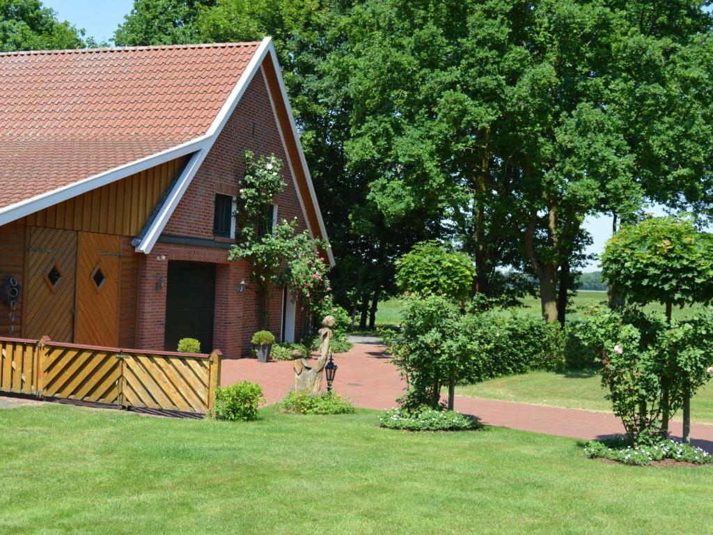 Eine Frau, die vor einem Haus steht. in der Unterkunft Holiday home in Lindern with garden in Werlte