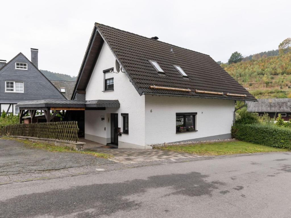 una casa blanca con techo negro en Cosy holiday home in Olsberg with garden, en Olsberg