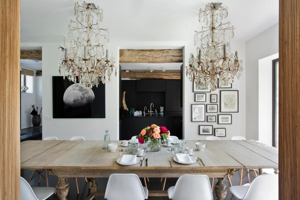 a dining room with a wooden table and chandeliers at B&B Park7 Wavre - Leuven in Huldenberg