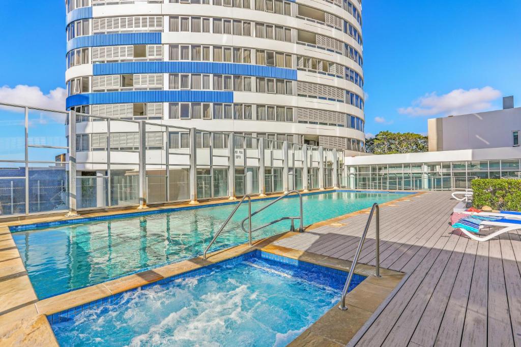a pool with a swimming pool and a tennis court at Tweed Ultima Apartments in Tweed Heads
