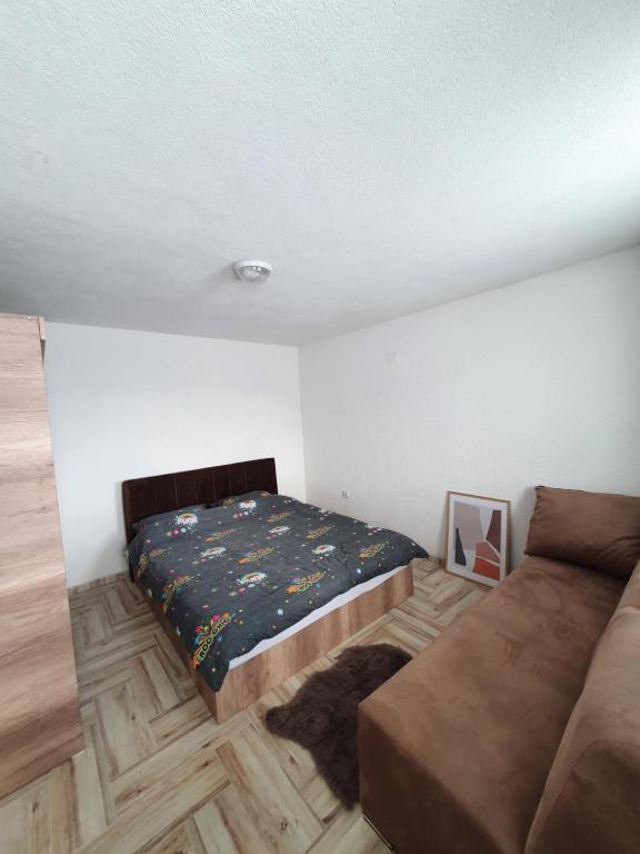 um quarto com uma cama e um sofá em Winterfell Apartment Popova Shapka em Popova Shapka