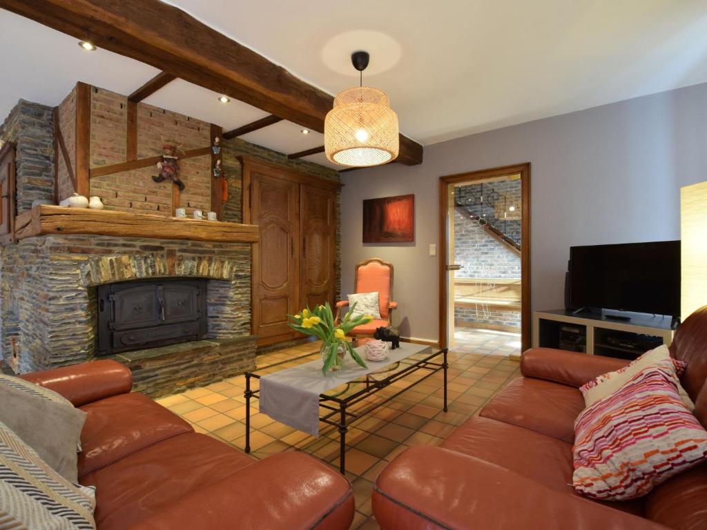 a living room with a couch and a fireplace at Cozy Holiday Home in Noville with Private Terrace in Luzery