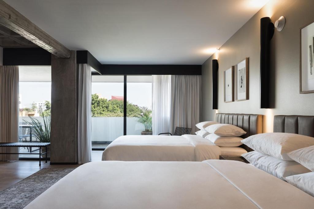 Postel nebo postele na pokoji v ubytování Bellwort Hotel