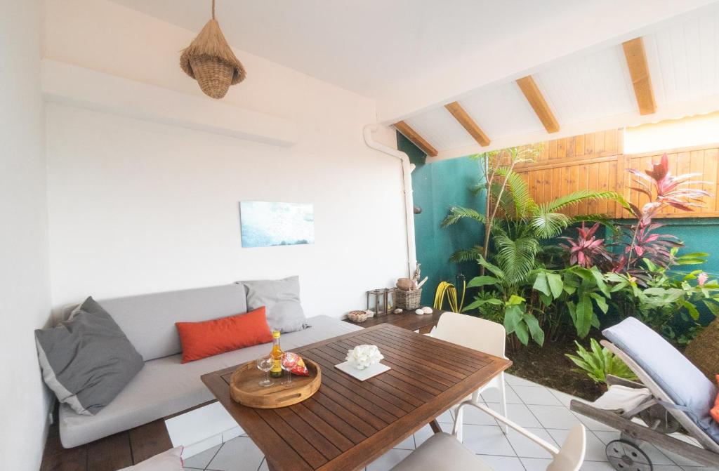 a living room with a couch and a table at Bungalow Anse Figuier in Terre-de-Haut