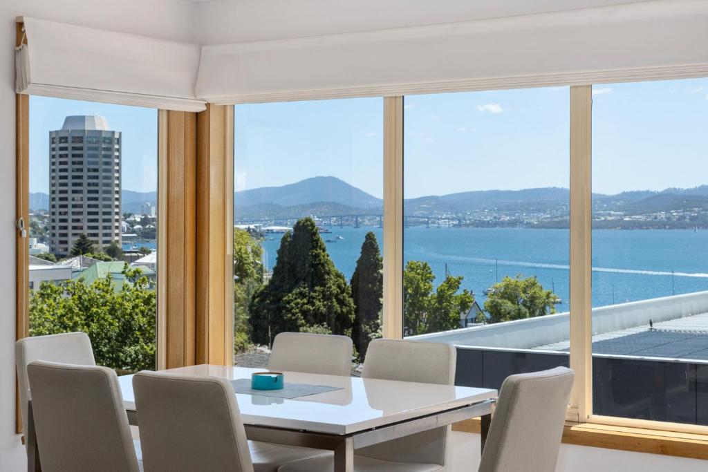 a dining room with a view of the water at Reflections on the Bay in Hobart