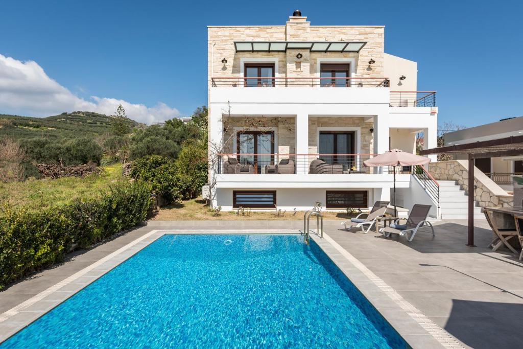 a villa with a swimming pool in front of a house at Villa Nina with Private Pool in Kolymvari