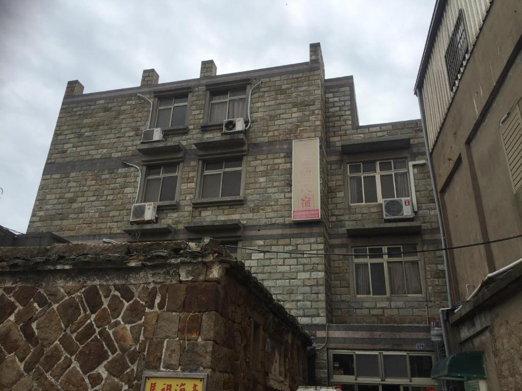 an old brick building with windows on a street at 美麗的民宿 可電洽民宿 in Beigan