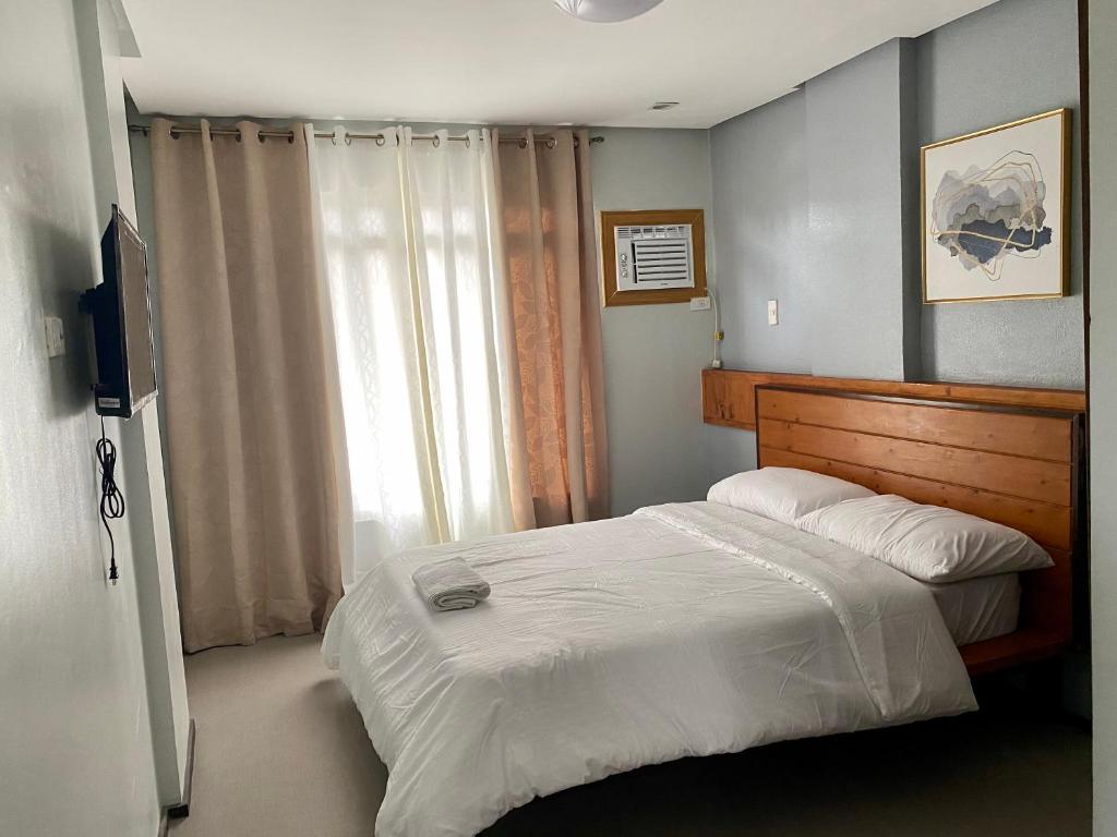 um quarto com uma cama grande e uma televisão em Philippa's Bed and Breakfast em Iloilo