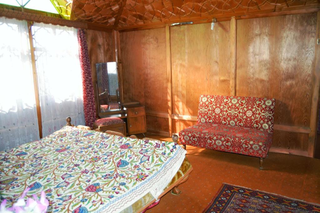 ein Schlafzimmer mit einem Bett und einem Stuhl in der Unterkunft Houseboat Young Manhattan in Srinagar