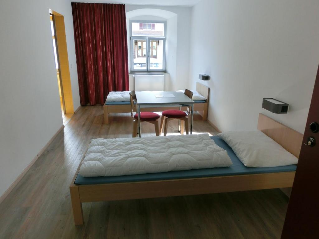 a room with a bed and two chairs and a table at Jugendherberge Rottweil in Rottweil