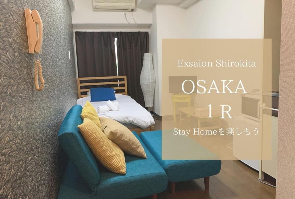 una camera con un divano blu e un letto di Exsaison Shirokita 307 ad Osaka
