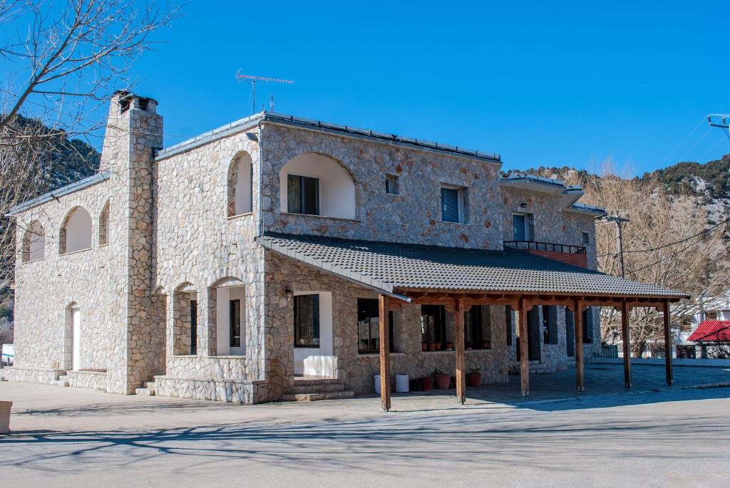 un antiguo edificio de piedra con cenador en Hotel Gigilos Omalos, en Omalos