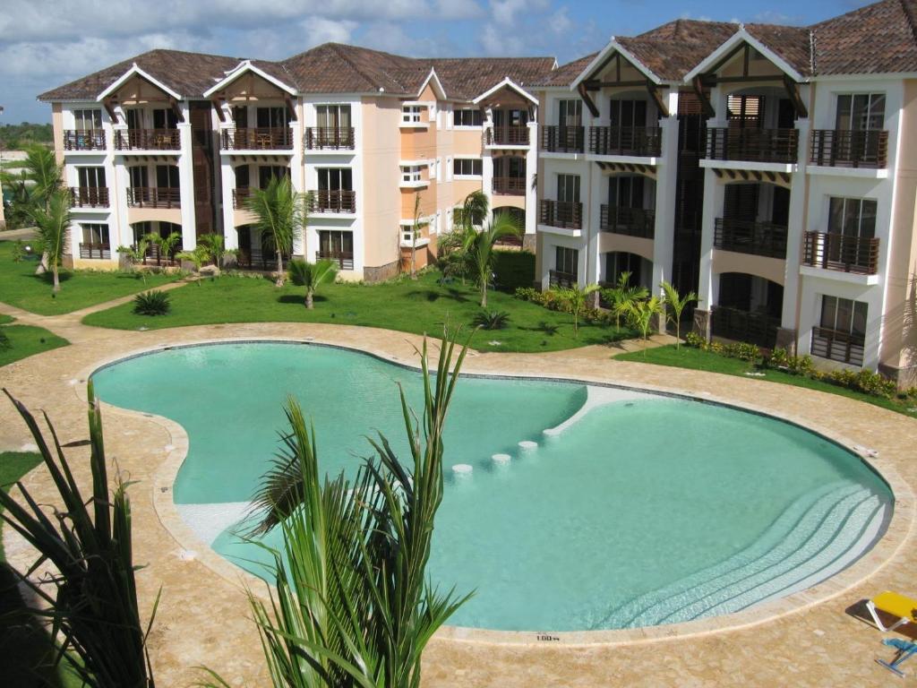 uma imagem de uma piscina em frente a um edifício em Laguna Golf em Punta Cana