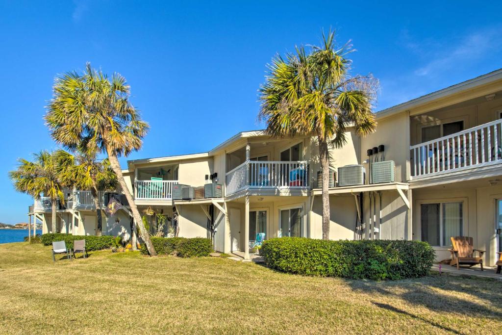 a large building with palm trees in front of it at Eco-Bungalow Condo Pensacola Beach Access! in Pensacola Beach