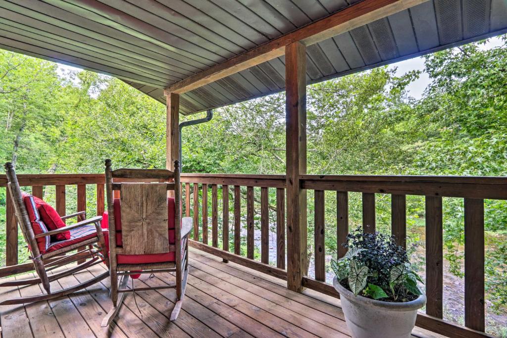 a porch with two chairs and a potted plant at Riverfront Couples Retreat in Smoky Mountains! in Townsend