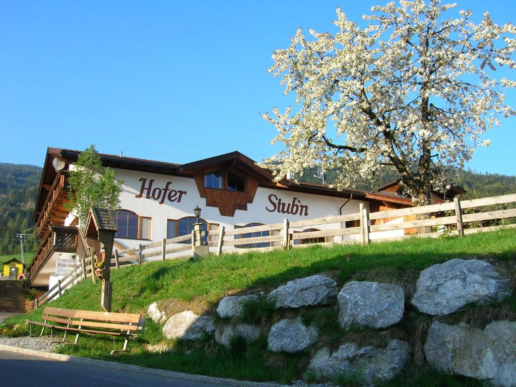 a building on a hill with a bench in front of it at Hofer Stubn in Kolsassberg