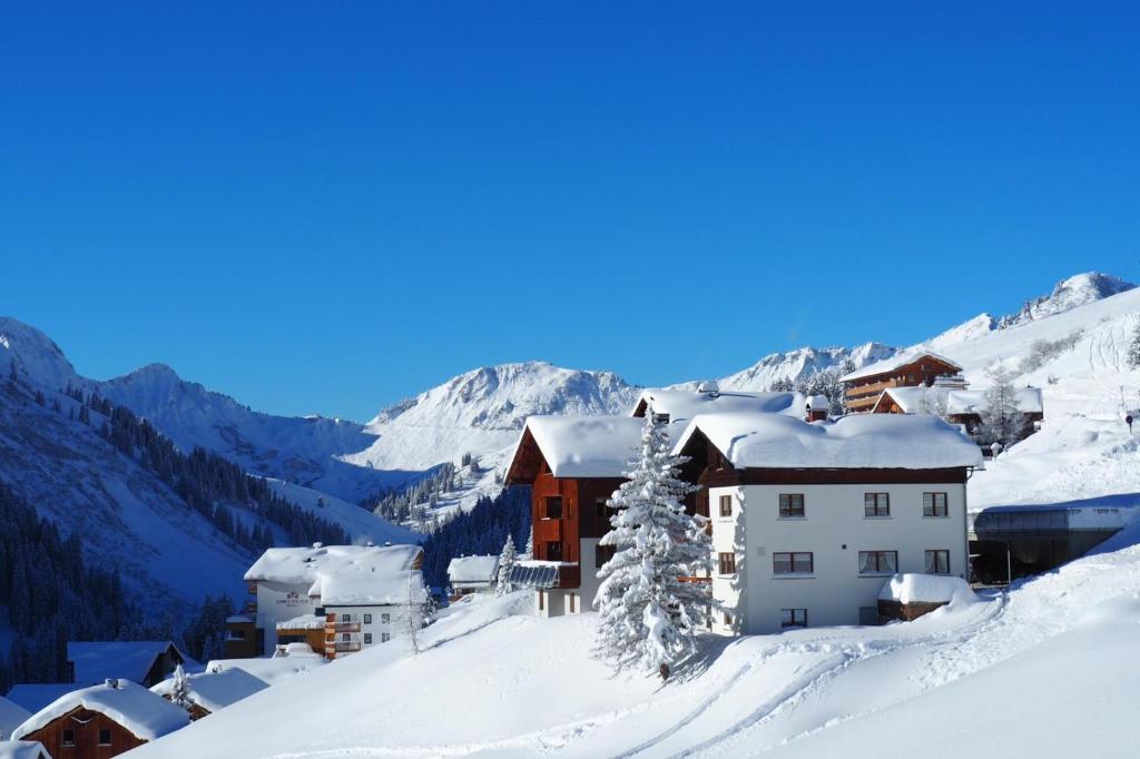 a ski resort in the mountains with snow covered roofs at Haus Furka in Damuls