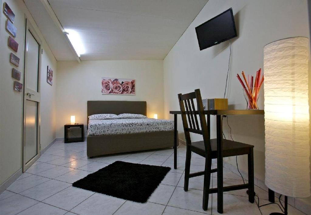 a bedroom with a bed and a table and a chair at A Casa di Claudio in Catania