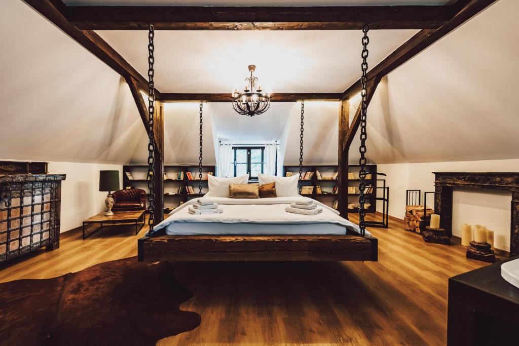 een slaapkamer met een hemelbed en een kroonluchter bij Resort Mlýn Černovice in Černovice