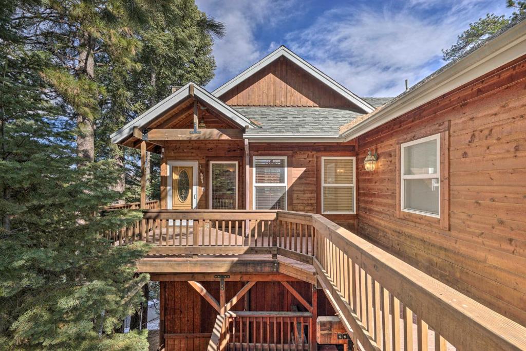 a home with a wooden deck in the woods at Bears Den Cabin with Fenced-In Yard 5 Mi to Lake in Lake Arrowhead