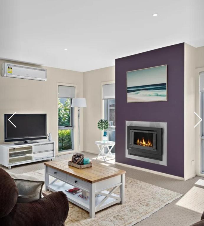 a living room with a fireplace and a tv at Redwood Delight in Cowes