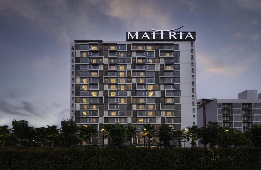 a large building with a sign on top of it at Maitria Hotel Rama 9 Bangkok - A Chatrium Collection in Bangkok