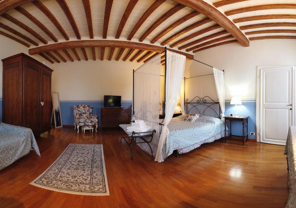 um quarto com uma cama de dossel e piso em madeira em Attico sulla Torre em Pisa