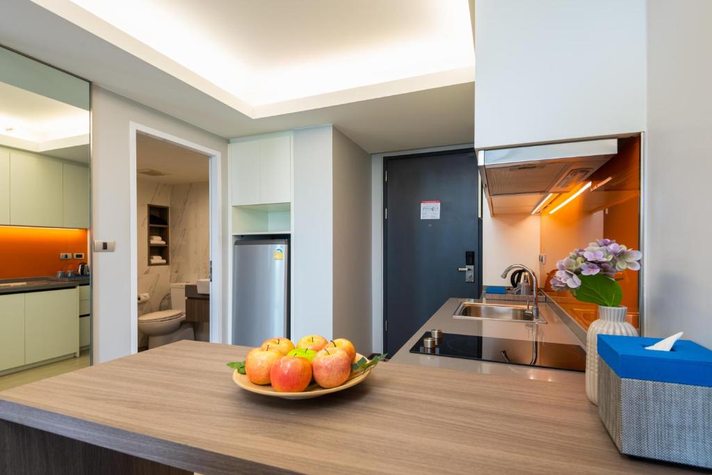 A compact apartment kitchen with a two-seat counter and fruit bowl.