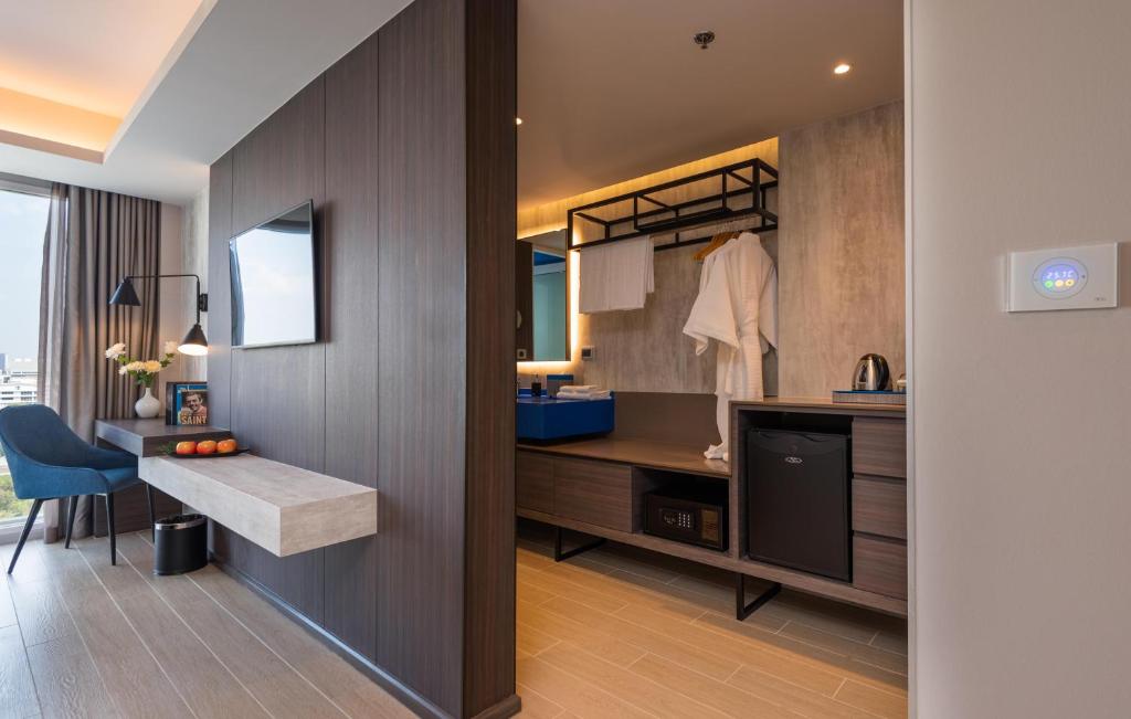 A room interior showing the desk, TV wall and open vanity area.