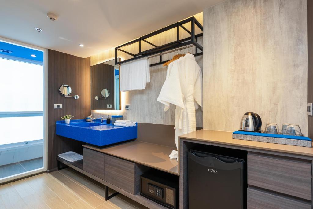 An open-plan vanity and dressing area with robes, minibar and tea setup.