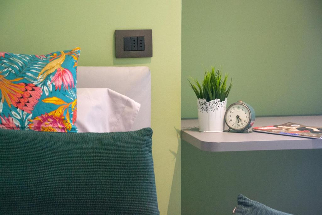 a room with a pillow and a clock on a shelf at Casa Dante - WelcHome in Stresa
