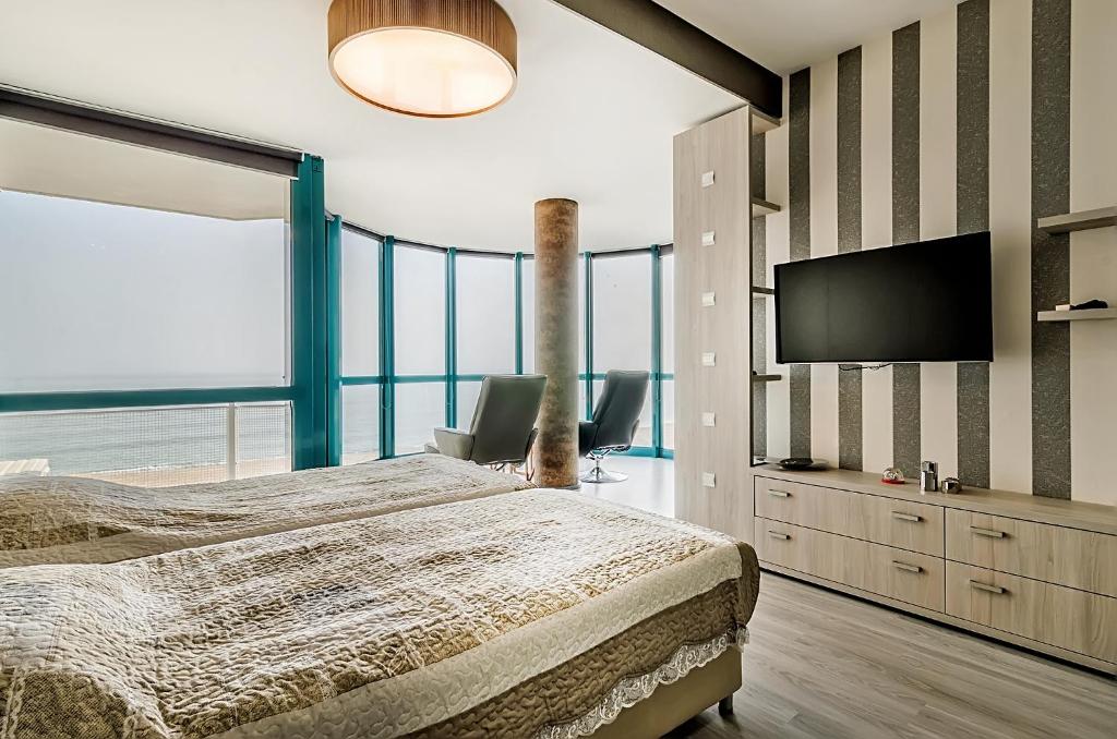 um quarto com uma cama e uma televisão de ecrã plano em Alek Apart Golden Sands em Golden Sands