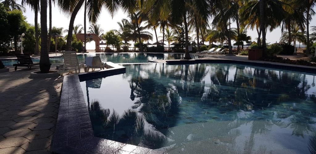 uma piscina com palmeiras num resort em safari village case 29 em Saly Portudal