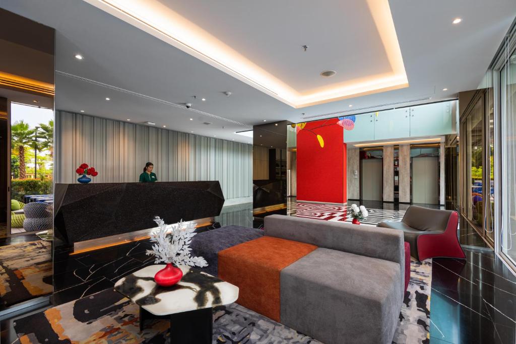A polished lobby lounge with a reception desk, sofas and elevator doors.