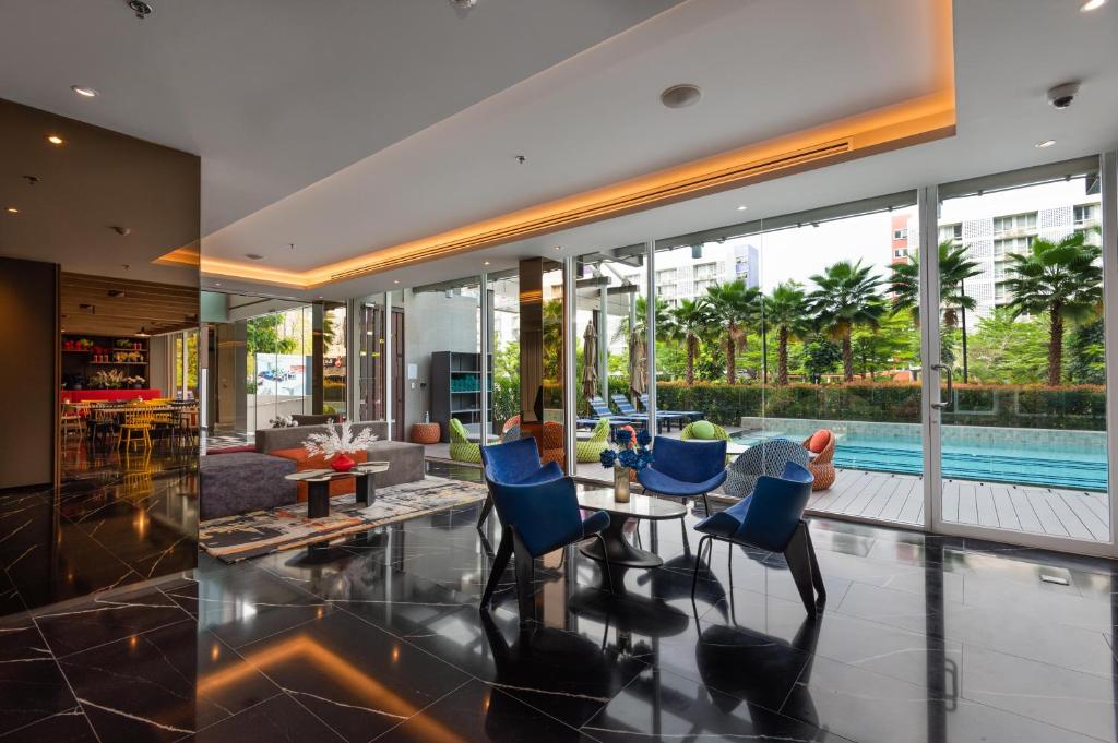 A window-lined lobby seating area overlooking the outdoor pool.