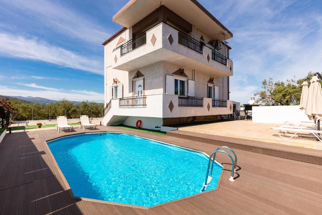 a villa with a swimming pool in front of a house at Villa Kounoupas in Lamerianá