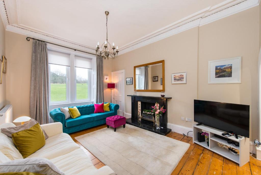 a living room with a couch and a tv at Arthur's Seat View in Edinburgh
